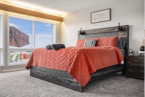a bedroom with a bed with a red comforter and a window at Majestic VIEWS FunAmenities & Best for Huge Group in Council Bluffs
