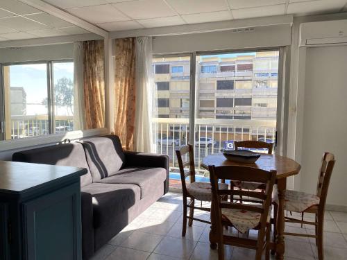 un salon avec un canapé et une table dans l'établissement T2 climatisé avec balcon, parking, et wifi – Balaruc-les-Bains - FR-1-553-224, à Balaruc-les-Bains