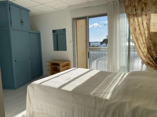 une chambre avec un lit et une grande fenêtre dans l'établissement T2 climatisé avec balcon, parking, et wifi – Balaruc-les-Bains - FR-1-553-224, à Balaruc-les-Bains