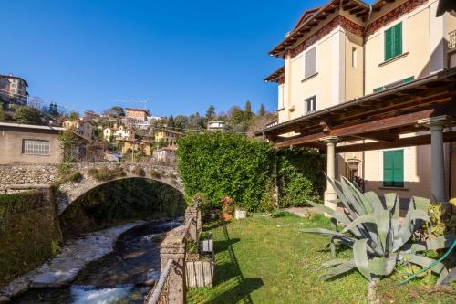 a bridge over a river next to a building at Le Acque Menaggio in Menaggio