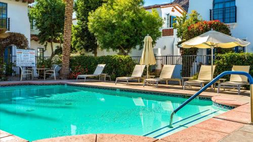 a swimming pool with chairs and an umbrella at SV006 Secluded Spa Villa Studio at LQ Resort in La Quinta