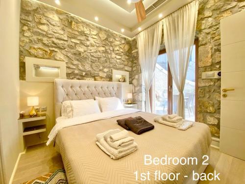 エルミオニにあるVillasonboard Rock Villa 3 Bed, 3 Bath, Jacuzzi, Seaside Ermioniのベッドとタオル2枚のある寝室