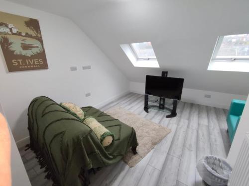 a living room with a couch and a piano at New Guest House, Individual Ensuite Rooms with Comfortable Double Beds, TV and WiFi in Luton