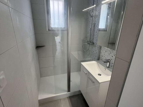 une salle de bain blanche avec une douche et un lavabo dans l'établissement Charmant T2 avec Jardinet, Parking Privé, à 150m de la Plage – Sud, 4 Pers. - FR-1-701-68, à Valras-Plage