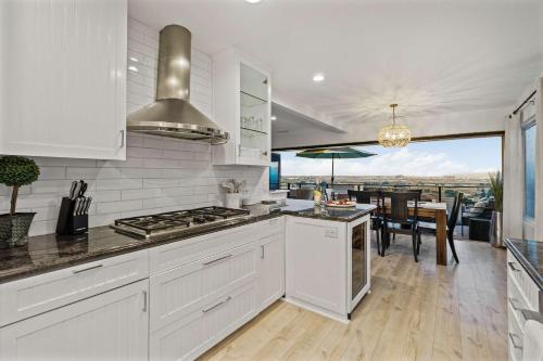 a white kitchen with a view of a dining room at The California - On Top of San Diego in a Hot Tub in San Diego
