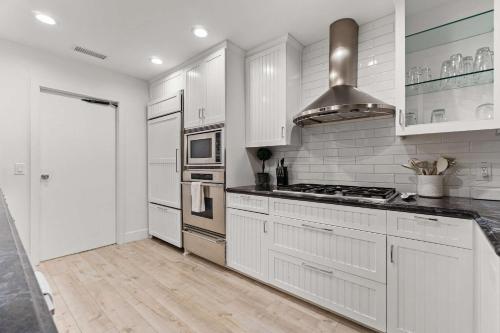 a kitchen with white cabinets and a stove top oven at The California - On Top of San Diego in a Hot Tub in San Diego