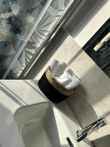 a basket of towels sitting on a counter next to a sink at Seaside two-room apartment in Torvaianica