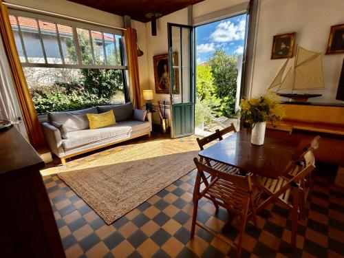 un salon avec une table et un canapé dans l'établissement Villa au Cap Ferret à 80mts de la plage et le marché, à Lège-Cap-Ferret