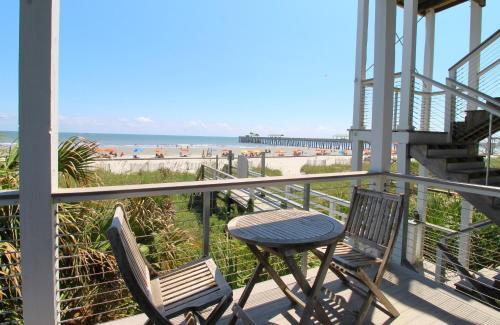 a balcony with a table and chairs and the beach at The One in Folly Beach
