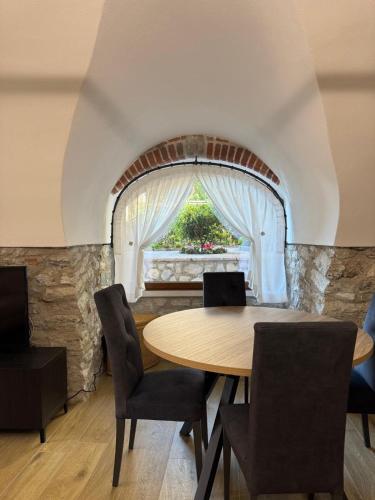 a dining room with a table and chairs and a window at Rustico cota in Tignale