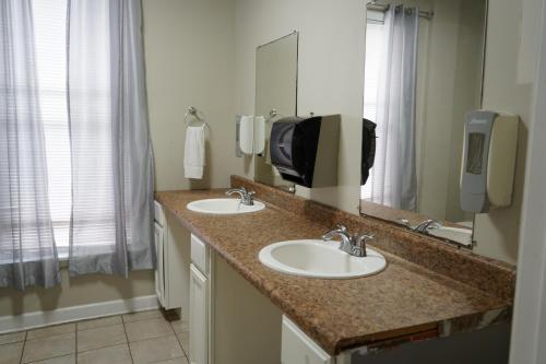 a bathroom with two sinks and a large mirror at Chic Midtown 6BR Main house and 3BR Cottage in Memphis