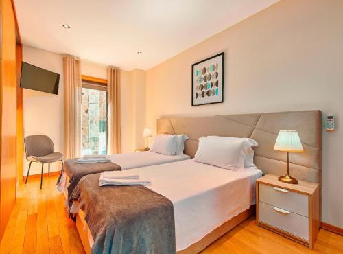 a hotel room with two beds and a window at Executive Townhouse, Tavira Centre, Shared Pool in Tavira