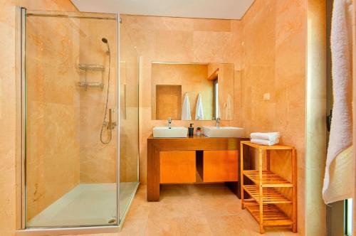 a bathroom with a glass shower and a sink at Executive Townhouse, Tavira Centre, Shared Pool in Tavira