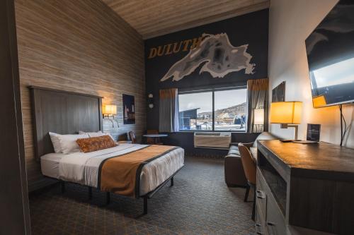 a hotel room with a bed and a desk at Pier B Resort in Duluth