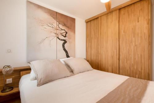 une chambre avec un lit et un tableau au mur dans l'établissement VILLAGE NATURISTE - Villa SAKURA Port Nature Luxe, au Cap d'Agde