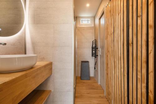 une salle de bain avec un lavabo et un miroir dans l'établissement VILLAGE NATURISTE - Villa SAKURA Port Nature Luxe, au Cap d'Agde