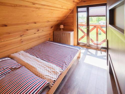 a bed in a wooden room with a window at House in Niechorze near Baltic Sea Beach in Niechorze