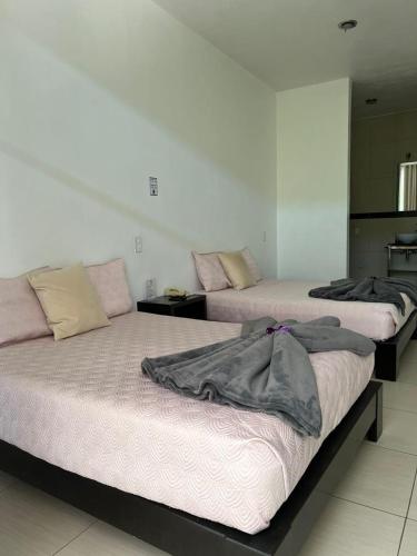 two beds sitting next to each other in a room at Rancho Macloy Hotel Spa & Social Events in Yautepec