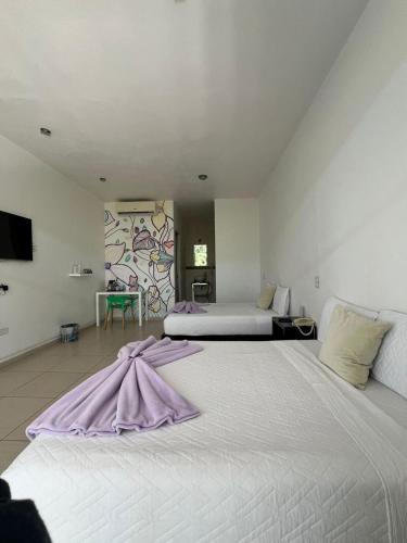 a large white bed with a dress on top of it at Rancho Macloy Hotel Spa & Social Events in Yautepec