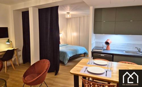 une chambre d'hôtel avec une table et un lit dans l'établissement La Maison de Clocheville - Appartements tout confort, à Boulogne-sur-Mer