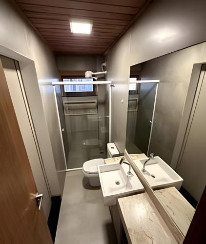 a bathroom with a toilet and a sink and a mirror at Casa em condomínio no centro de Barra Grande - Vila Tamarindo in Barra Grande