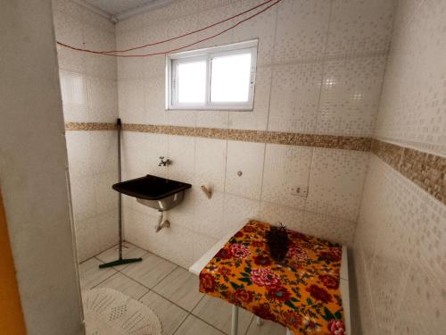 a small room with a bed and a window at Hospedagem da Lu in Paraty