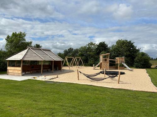 a playground with two swings and a pavilion at Bolding Apartments in Billund
