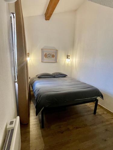 une petite chambre avec un lit dans une pièce dans l'établissement Maison T2 RDC, à Perpignan