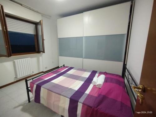 a bedroom with a bed with a purple and white blanket at Appartamento la casa di ele in Monsano