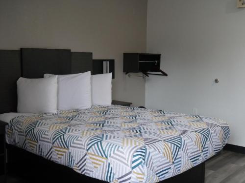 a bedroom with a bed with a colorful comforter at Motel 6-Tacoma, WA - South in Tacoma