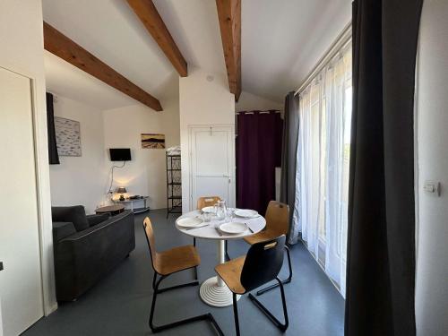 un salon avec une table, des chaises et un canapé dans l'établissement Studio rénové avec piscine, balcon, à 700m de la plage - Narbonne Plage - FR-1-229B-99, à Narbonne