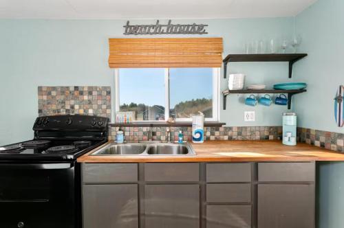 a kitchen with a sink and a stove and a window at Breakwater Resort in Grayland