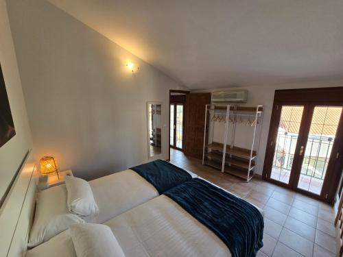 a bedroom with a white bed with a blue blanket at Hotel Puerta del Arco in Tudela de Duero