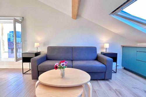 un salon avec un canapé bleu et une table dans l'établissement Studio rénové et fonctionnel, à Bron