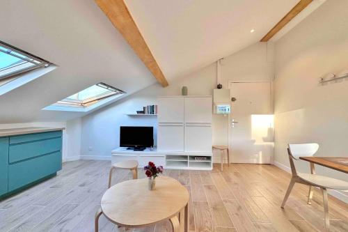 un salon avec une table et une télévision dans l'établissement Studio rénové et fonctionnel, à Bron