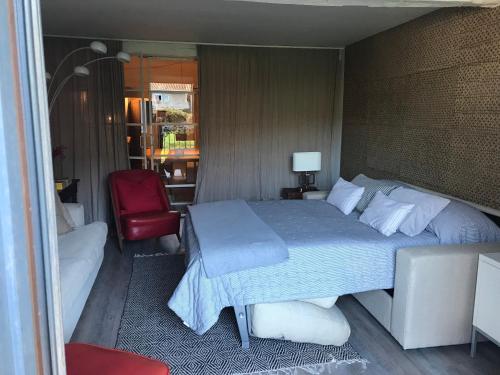 a bedroom with a bed and a red chair at donibane20 EBI02770 in Orduña