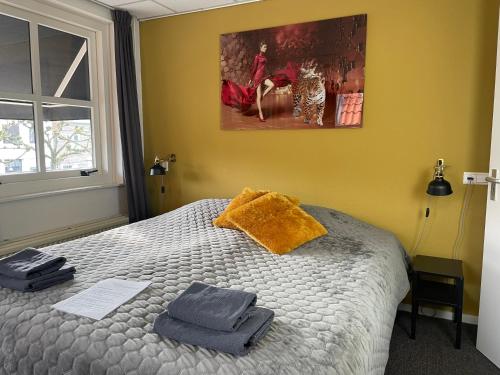 a bedroom with a bed with two towels on it at Hotel Willemstad in Willemstad