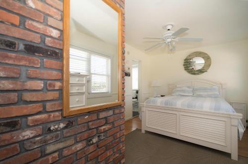 a bedroom with a brick wall and a mirror at The Montauk Soundview in Montauk