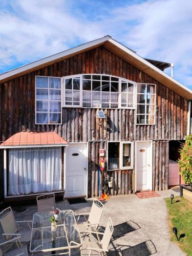 a barn with chairs in front of it at Hostal & Cabañas Don Juan in Villarrica