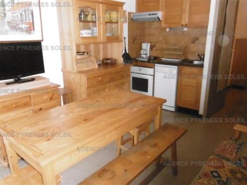 une cuisine avec des armoires en bois et une table en bois dans l'établissement Appartement cosy 4 pers. Les Angles, proche remontées et commerces - FR-1-295-200, aux Angles