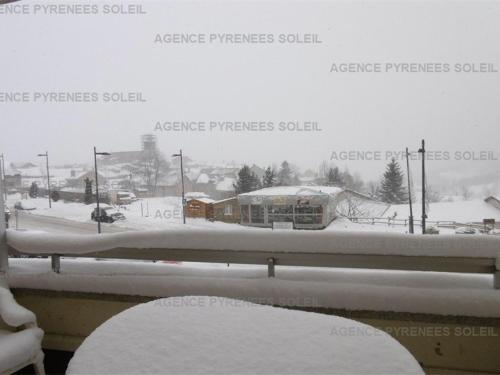 d'une fenêtre enneigée avec vue sur la rue. dans l'établissement Appartement cosy 4 pers. Les Angles, proche remontées et commerces - FR-1-295-200, aux Angles