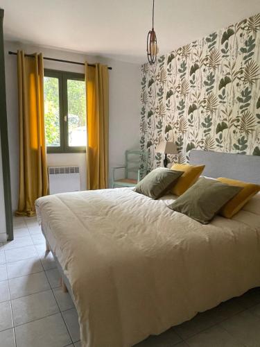 - une chambre avec un grand lit blanc et des rideaux jaunes dans l'établissement Chez Michèle, à Saint-Génis