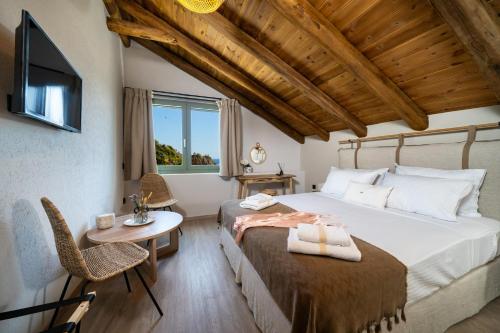 リメナリアにあるAnasa Thalassasのベッドとテーブルと椅子のある寝室