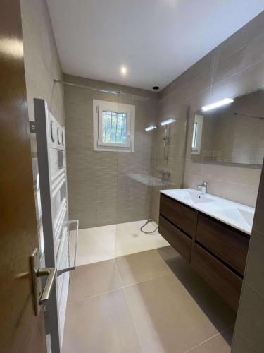 une salle de bain avec un lavabo, une baignoire et un miroir dans l'établissement Chez Michèle, à Saint-Génis