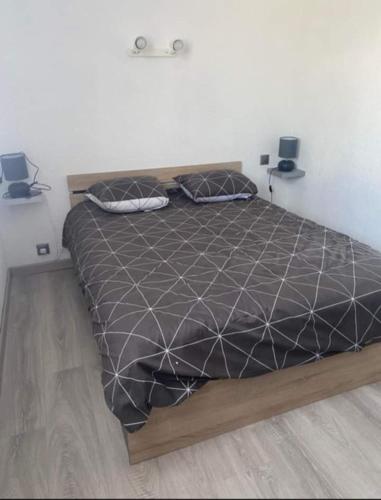 - une chambre avec un lit et une couette noire dans l'établissement Les marines d'helios, à Le Castellas