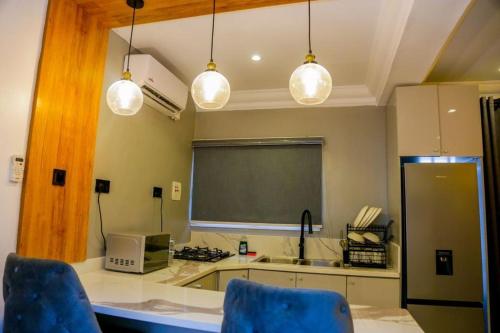 a kitchen with two blue chairs and a blackboard at DM Apartments in Ilado