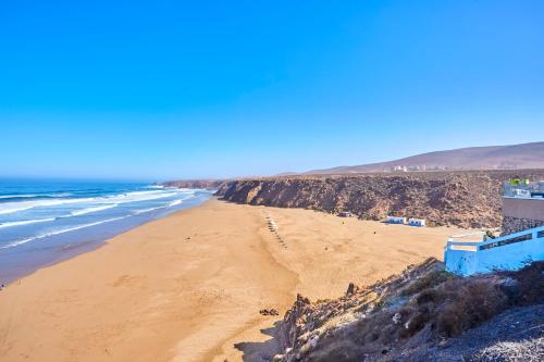 a view of a sandy beach with the ocean at Amwaj Apt - Surf and Fun Beachfront Stay With Balcony in Mirleft