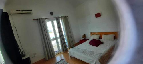 a bedroom with a bed and a large window at Casa loud in Sidi el Moujahed