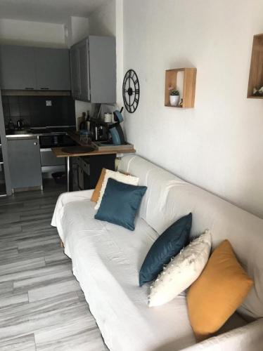 - un canapé blanc avec des oreillers dans la cuisine dans l'établissement Résidence Verdon - Coquet appartement 2 couchages à Six Fours les Plages MAE-7531, à Six-Fours-les-Plages