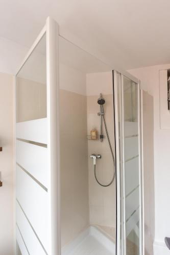 une salle de bain avec une douche avec une porte vitrée dans l'établissement Versailles Rustic - Charm & Comfort 7min Palace, à Le Chesnay